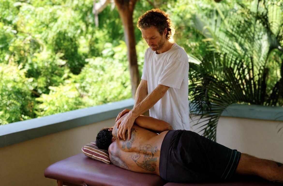 Jan treating a patient's shoulder blade on the treatment table